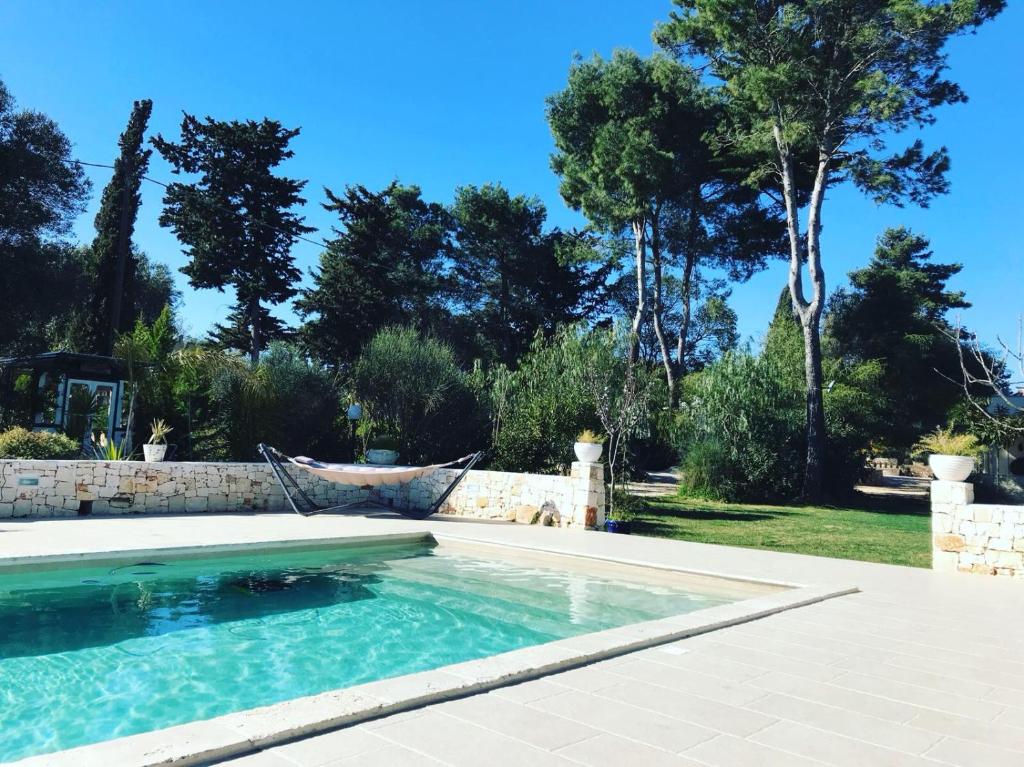una piscina en un patio con árboles en Il Saraceno B&B, en Carovigno