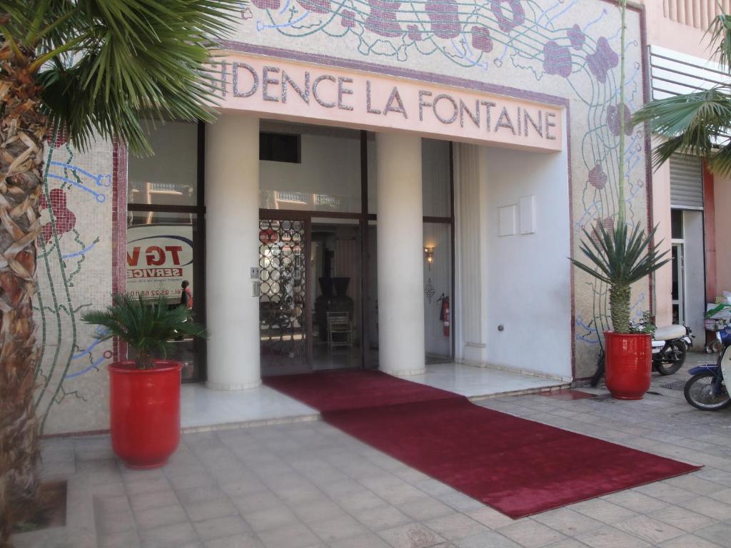 una entrada a un edificio con una alfombra roja delante en La Fontaine, en Marrakech