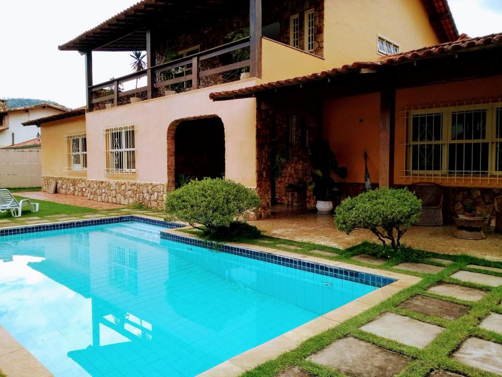 a swimming pool in front of a house at Sua Casa na Serra in Itaipava