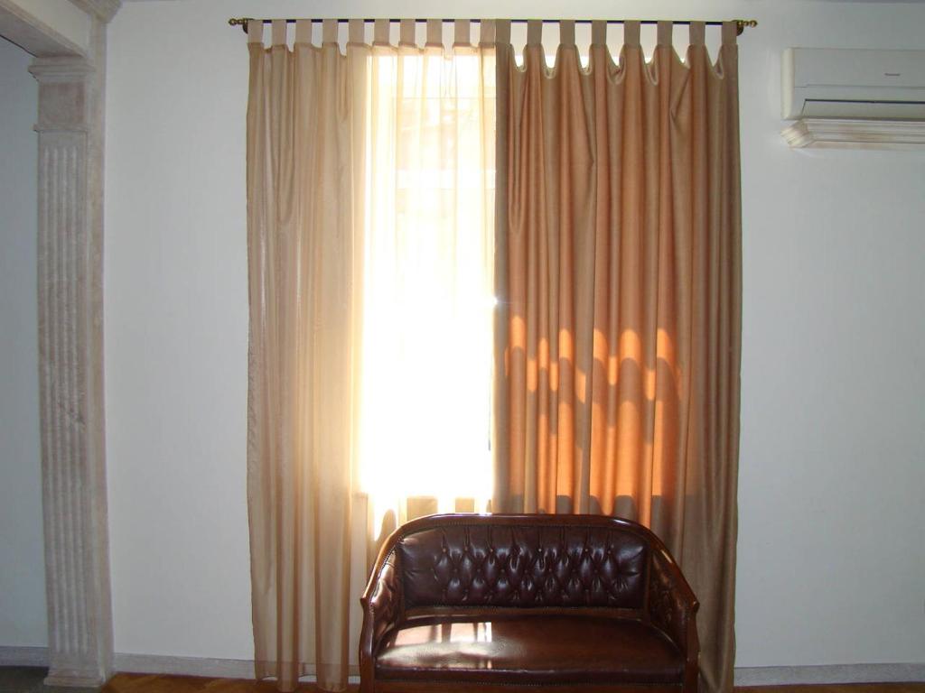 un canapé en cuir brun devant une fenêtre dans l'établissement Best choice in the heart of Yerevan, à Erevan