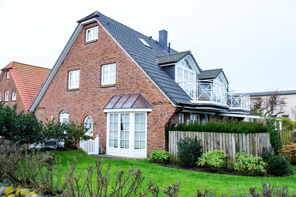a brick house with a balcony on top of it at App-Syltperle in Westerland (Sylt)