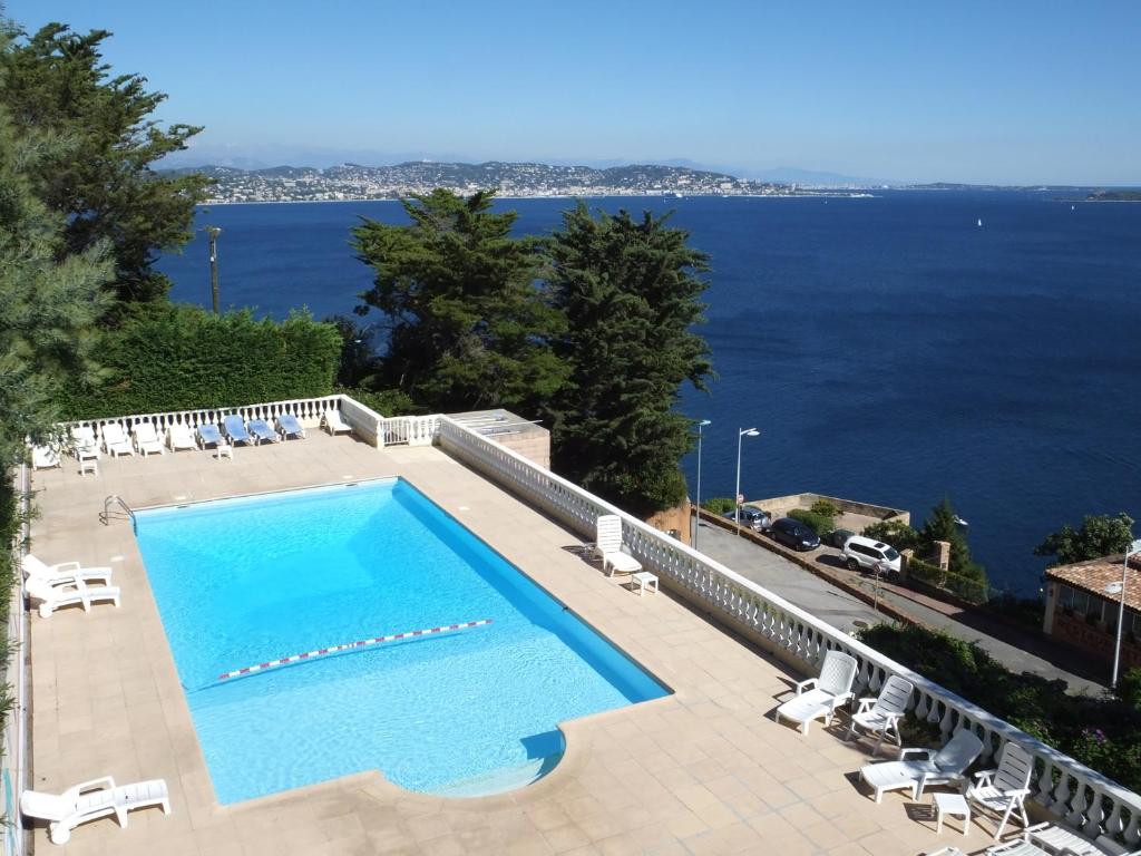 een zwembad met uitzicht op het water bij Association Villa Saint Camille in Théoule-sur-Mer