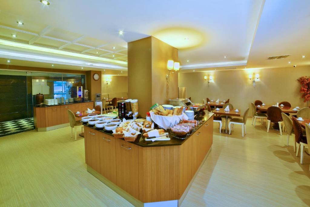 a restaurant with a buffet with tables and chairs at Hotel Grand Emin in Istanbul