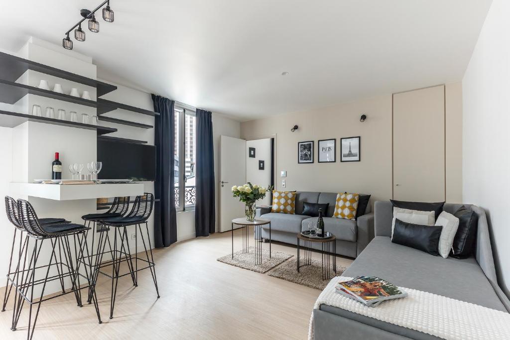 a living room with a couch and a table at Résidence Palais Étoile in Paris