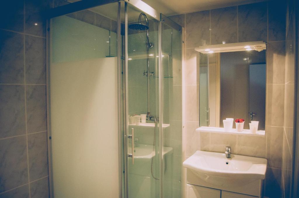 a bathroom with a glass shower and a sink at Hotel Restaurant Maurice in Châteauroux