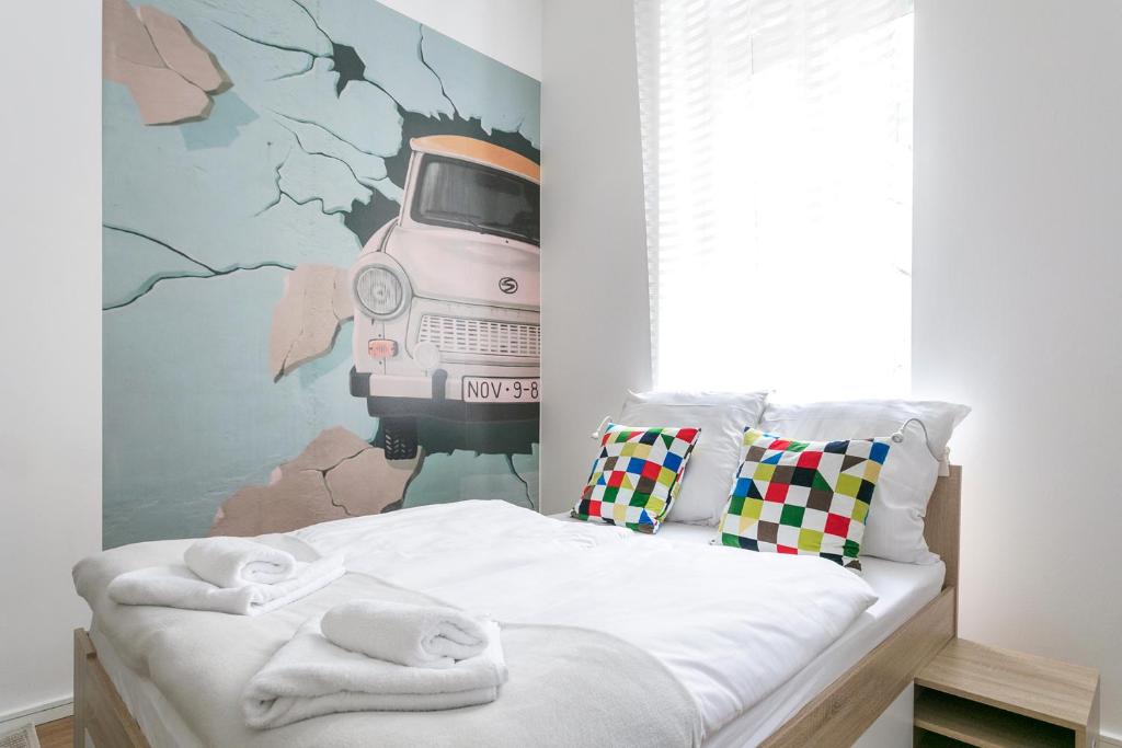 ein Schlafzimmer mit einem Bett mit einem Gemälde eines Autos in der Unterkunft Studio Apartment for 3 in Berlin