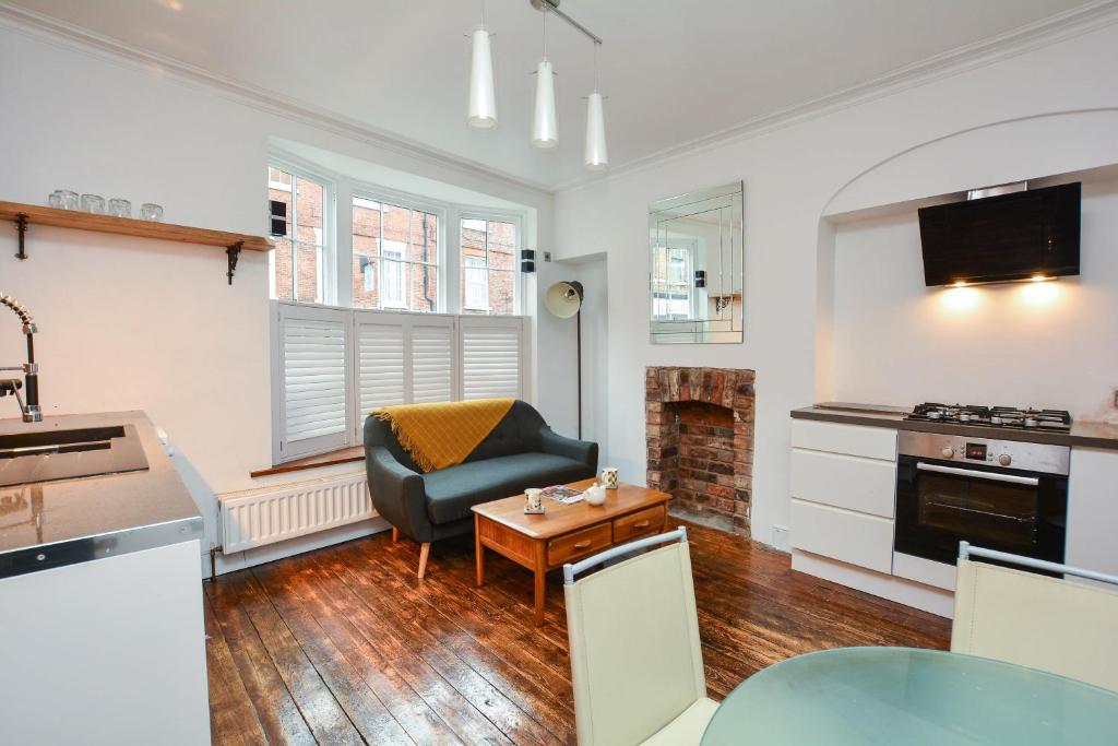 a kitchen and living room with a chair and a table at The LOCATION- 1 FREE PRIVATE PARKING SPACE - 60 SECOND WALK 2 MINSTER! in York