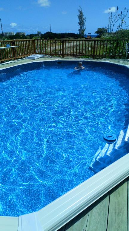 a man is in a large blue swimming pool at The Pool House in Saint Philip