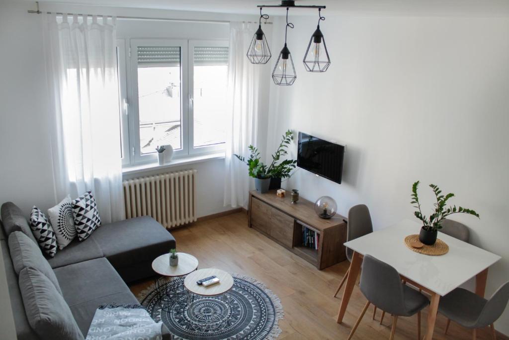 uma sala de estar com um sofá e uma mesa em Bardolino Apartment em Belgrado