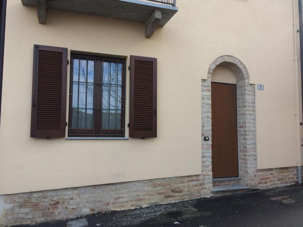 a building with two windows and a door at Appartamento Riva in Neive