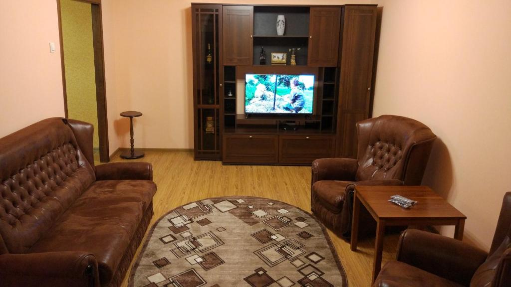 エッセントゥキにあるАпартаменты в центреのリビングルーム(革張りの椅子2脚、テレビ付)