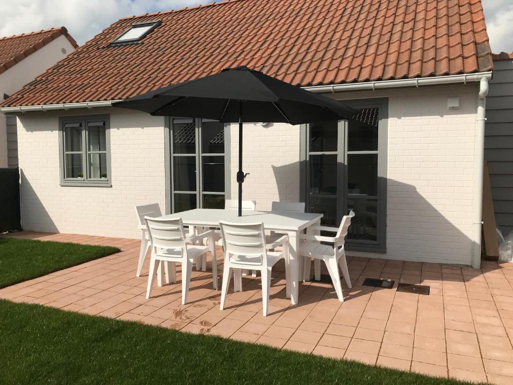 a table and chairs with an umbrella on a patio at Zeepark Mercator in Molenwijk