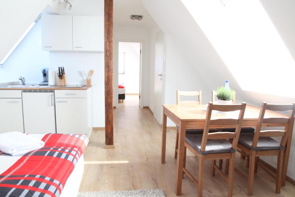 a kitchen and dining room with a table and chairs at Schwaben Apartment in Oberboihingen