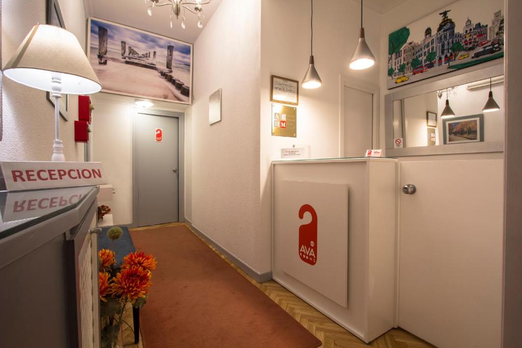 una camera con corridoio, bancone della reception e porta di AVA Rooms a Madrid