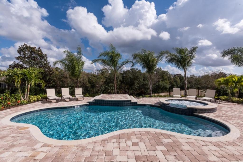 a swimming pool with chaise lounge chairs and a patio with a swimming poolvisor at Castle Villa #1069 in Kissimmee
