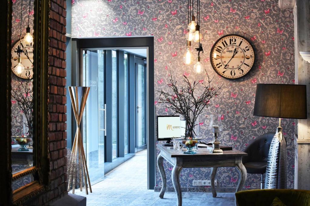 Cette chambre comprend un miroir, une table et une horloge. dans l'établissement MOMENTS Boutique Hotel, à Bautzen