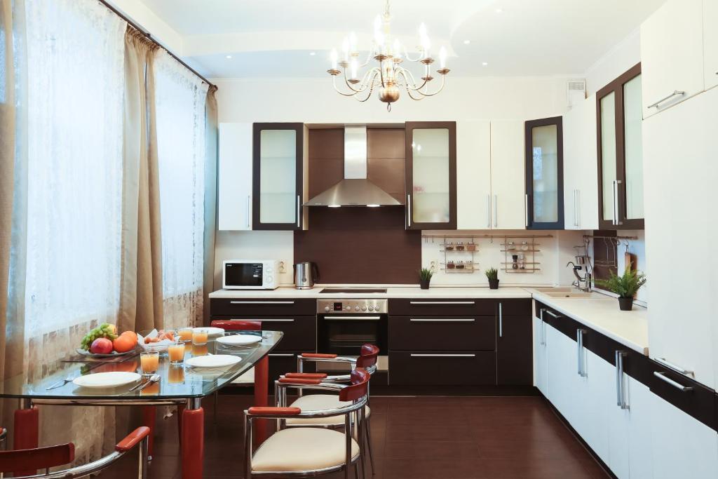 uma cozinha com mesa e cadeiras e um candelabro em Family Apartment em Kazan