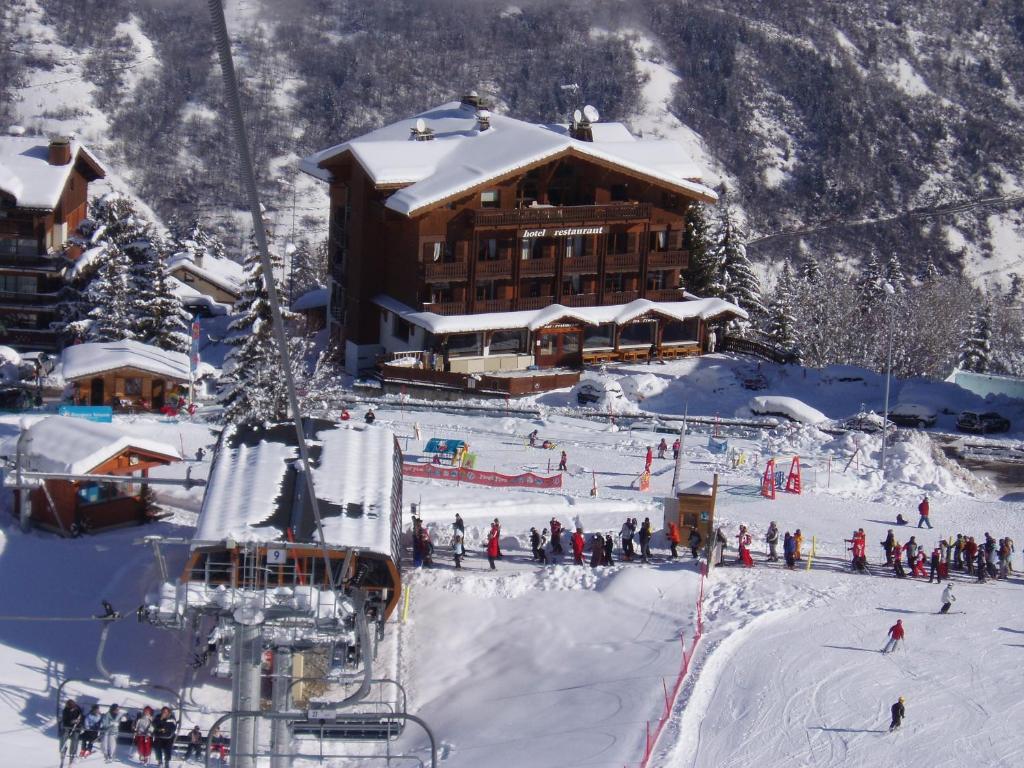 a group of people on a ski lift in front of a ski lodge at Hotel les Flocons in Courchevel