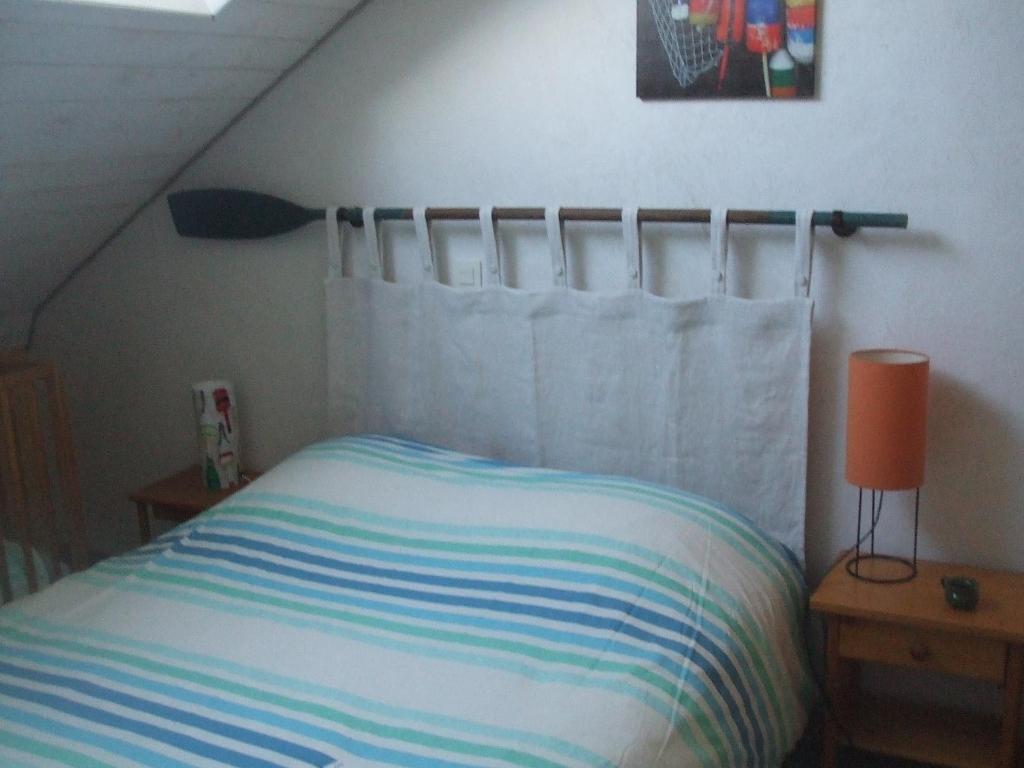 サルゾーにあるMaison de Pêcheursのベッドルーム1室(ストライプ毛布付きのベッド1台付)