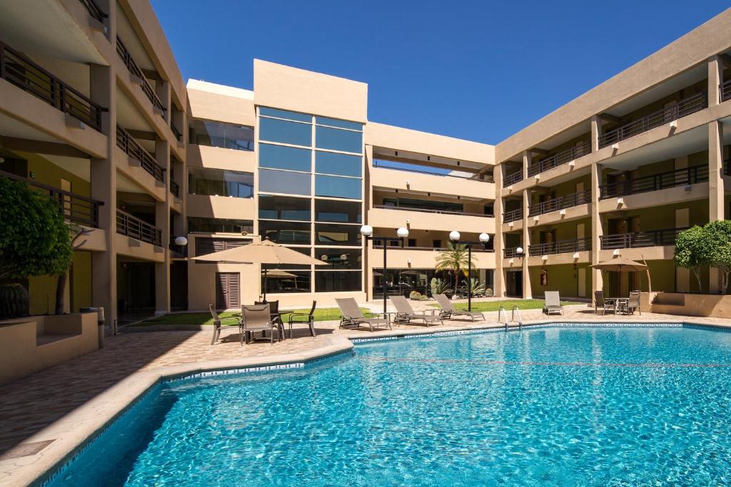 a swimming pool in front of a building at Hotel Araiza Hermosillo in Hermosillo