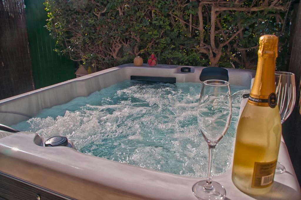 a bottle of champagne and a wine glass in a tub at Charming House in Maspalomas
