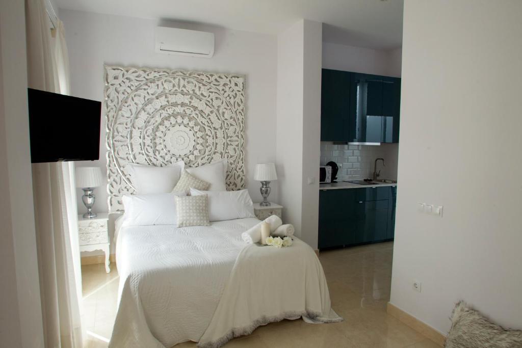 - une chambre avec un grand lit et des draps blancs dans l'établissement Luxury Dreams Sevilla, à Séville