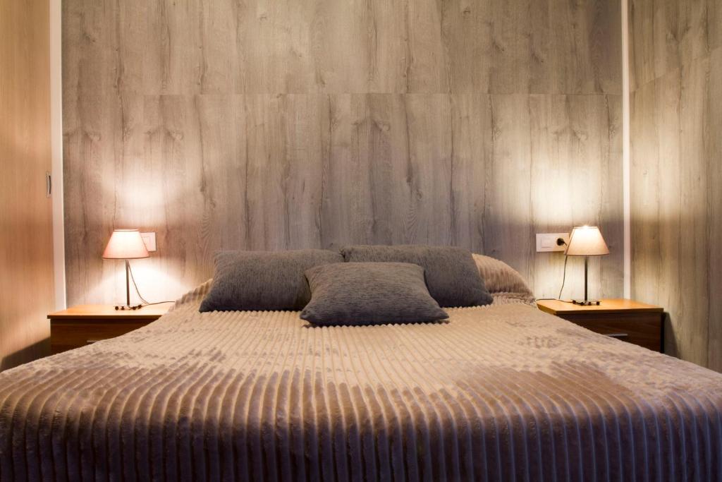 een slaapkamer met een groot bed met 2 lampen bij Vivienda Rural Alba in Los Albaricoques