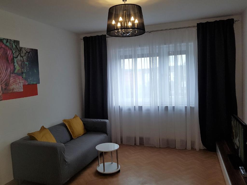 - un salon avec un canapé et une fenêtre dans l'établissement GreatStay Saarbrücken, à Sarrebruck