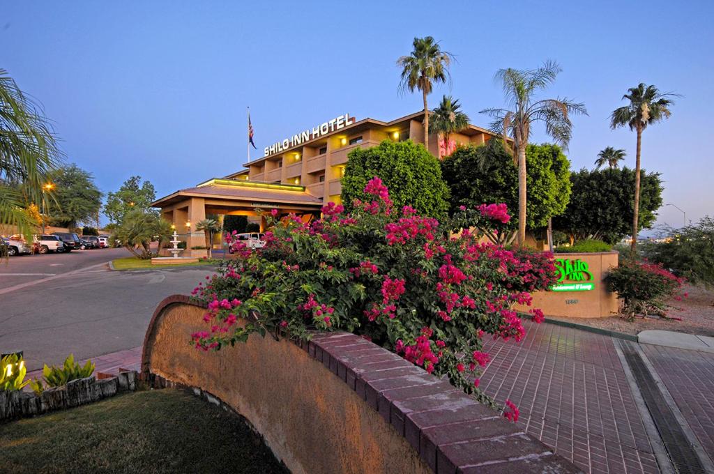 a retaining wall with flowers in front of a hotel at Shilo Inn Yuma in Yuma