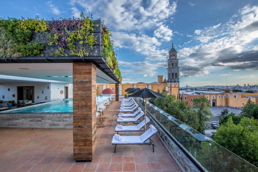 a row of lounge chairs on the roof of a building at Banyan Tree Puebla in Puebla