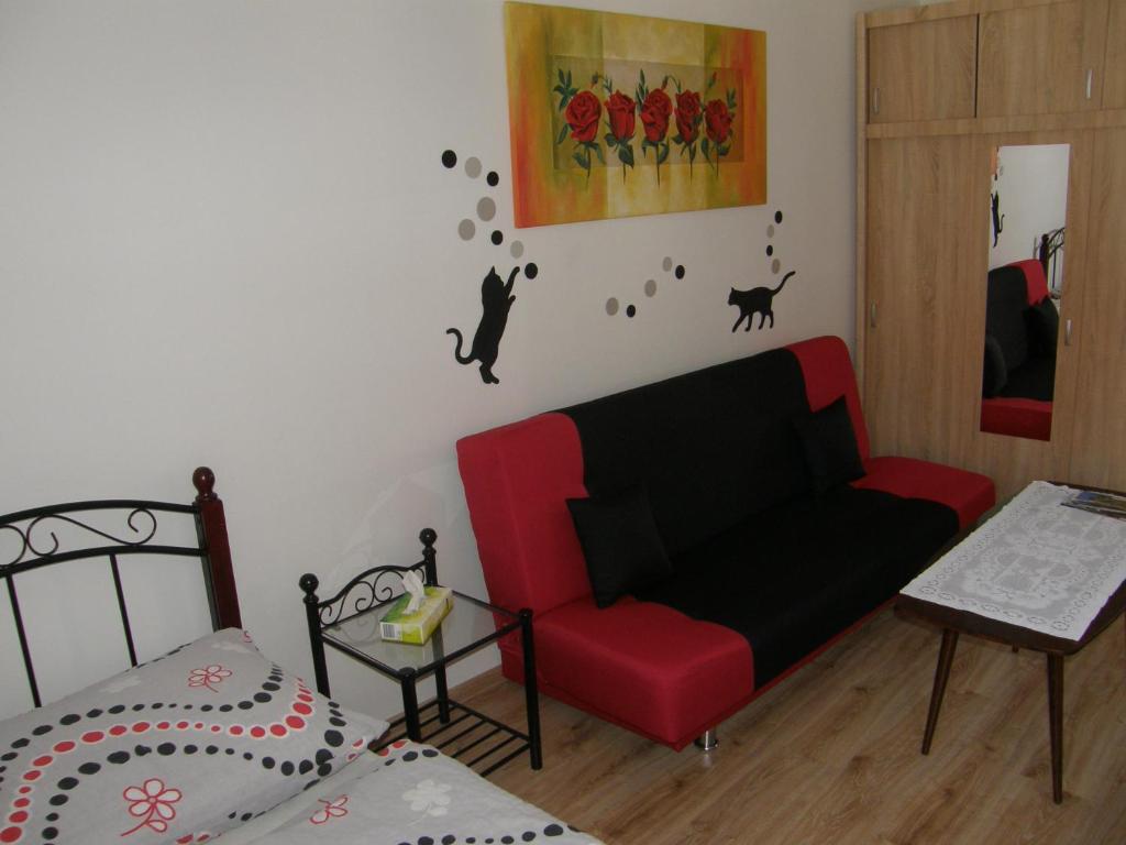 un soggiorno con divano rosso e letto di Apartmán Marie a Cesky Krumlov