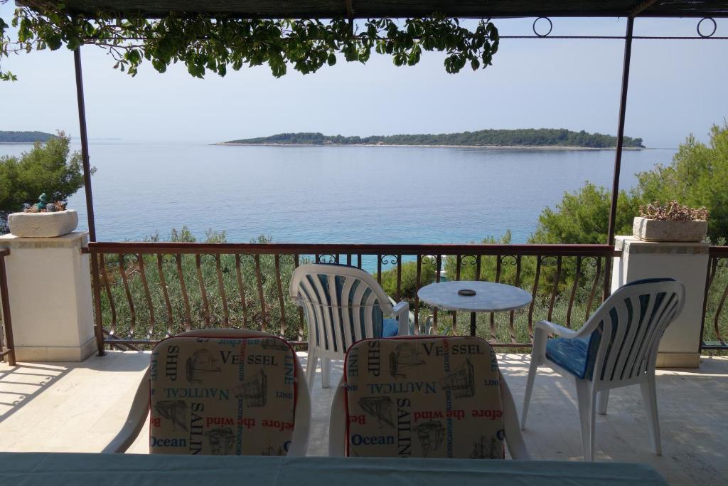 a table and chairs with a view of the water at Apartmani Surjan in Vela Luka