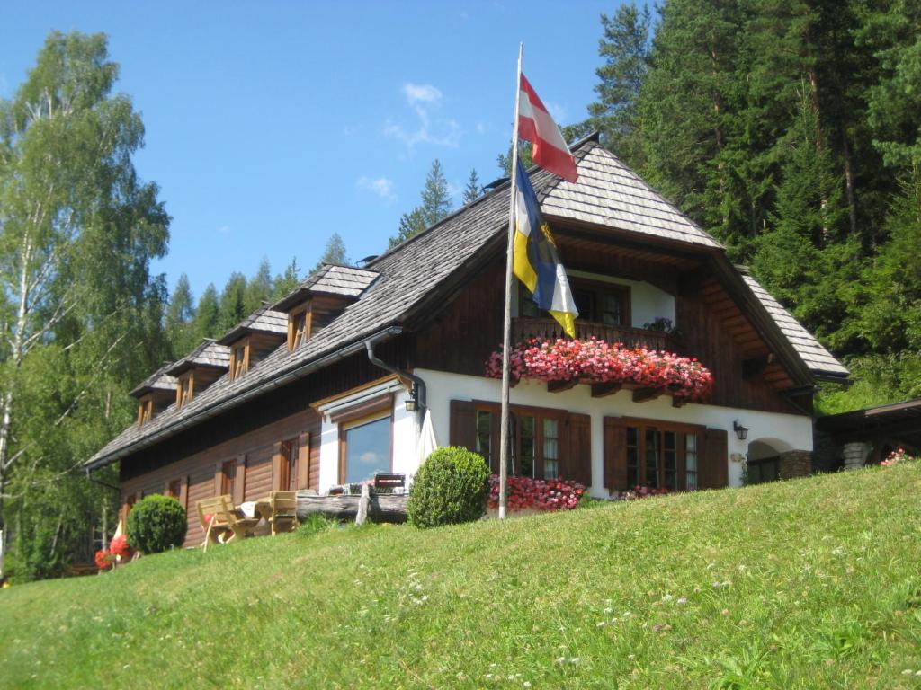 uma casa no topo de uma colina com uma bandeira em Alpenhaus Ganser-Dixit em Mariazell