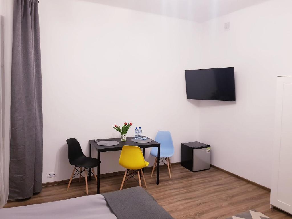 a room with a table and chairs and a tv at Guest Room RÓWNA in Kielce