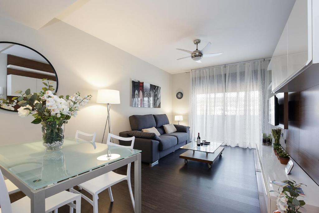 a living room with a blue couch and a table at Atico Be suite Granada in Granada