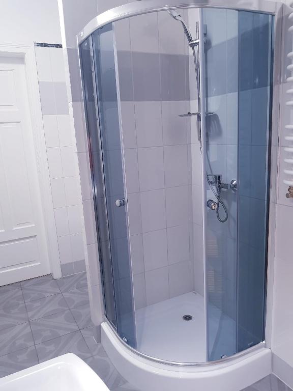 a glass shower in a bathroom with a toilet at Guest Room RÓWNA in Kielce