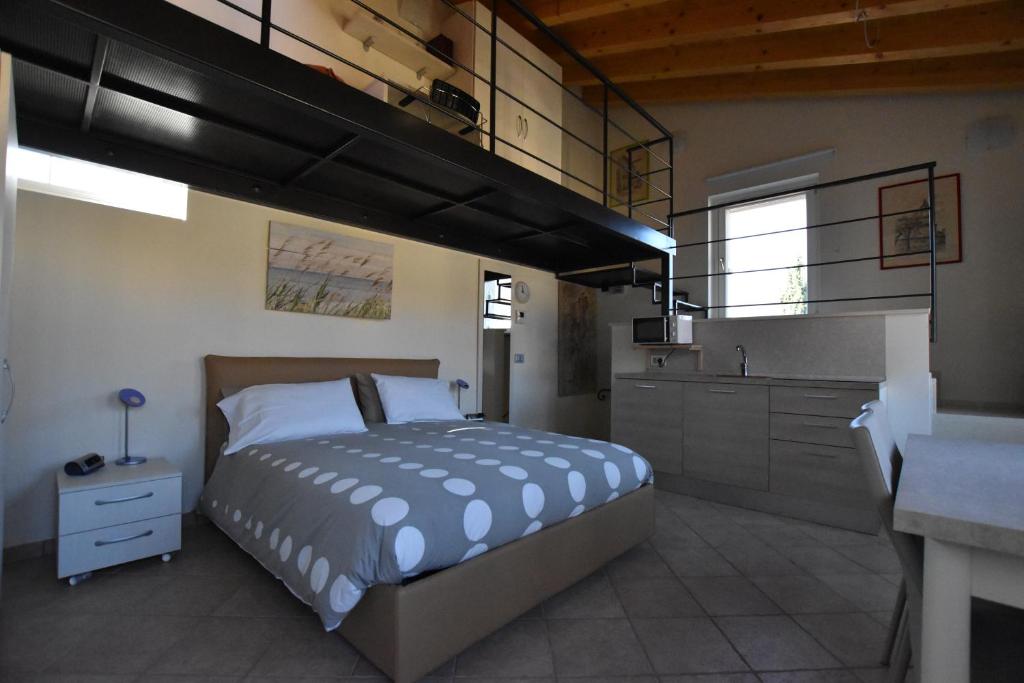 a bedroom with a large bed and a kitchen at Casa del Drago in Sulzano