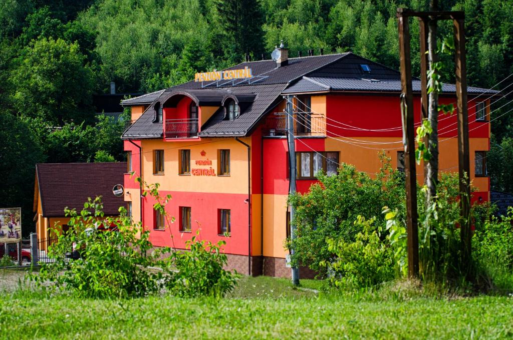 a red and orange house with a black roof at Penzión Centrál in Oščadnica
