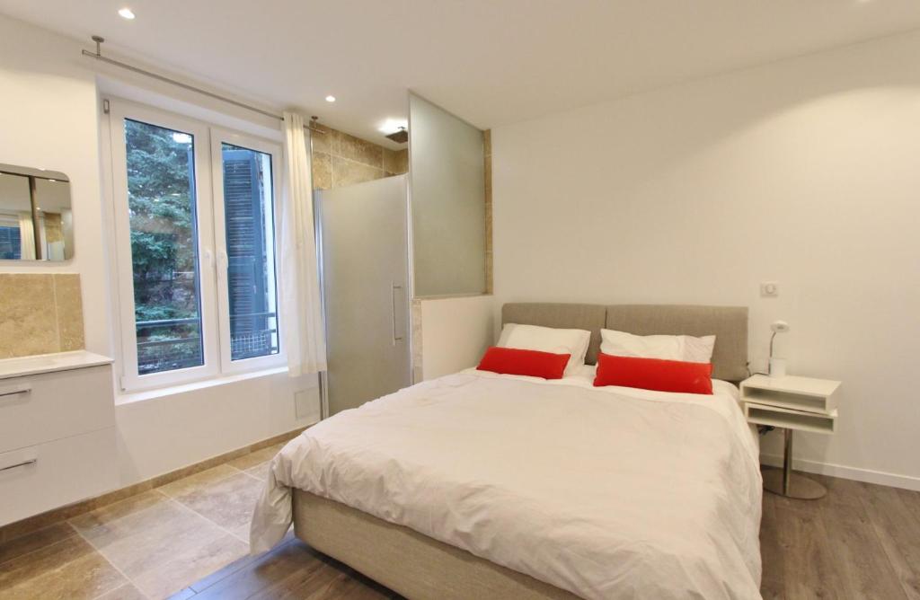 アンティーブにあるmagnifique 2 pièces vue merのベッドルーム1室(大型ベッド1台、赤い枕2つ付)
