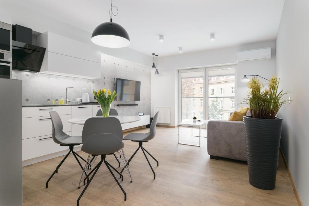 a kitchen and living room with a table and chairs at Venezia Apartment in Poznań