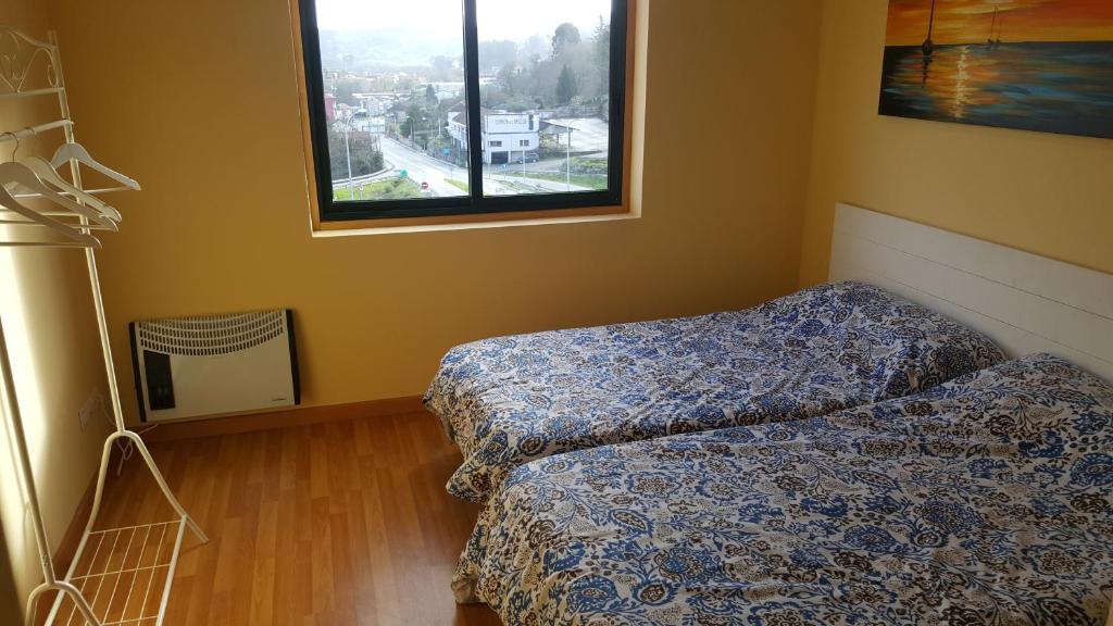 a bedroom with two beds and a window at Hospedaje Bahía de San Simon in Redondela