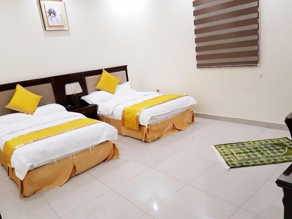 2 camas en una habitación con suelo blanco en New Home Furnished Units en Yanbu