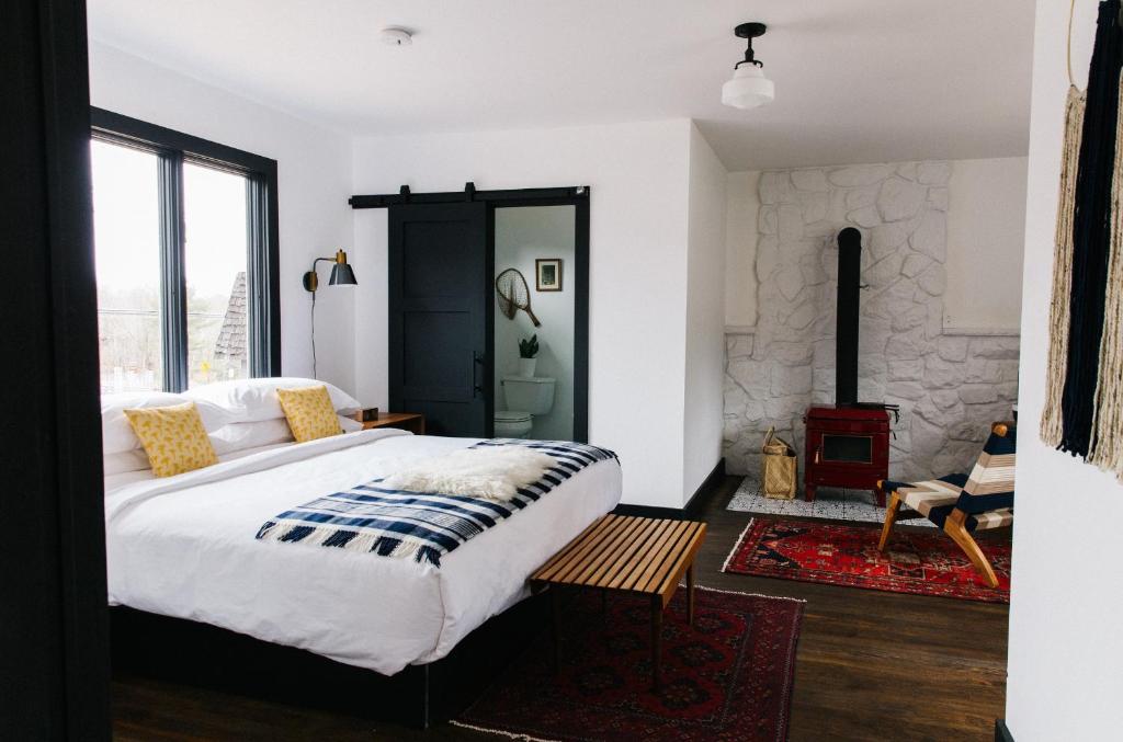 ein Schlafzimmer mit einem großen Bett und einem Kamin in der Unterkunft Eastwind in Windham