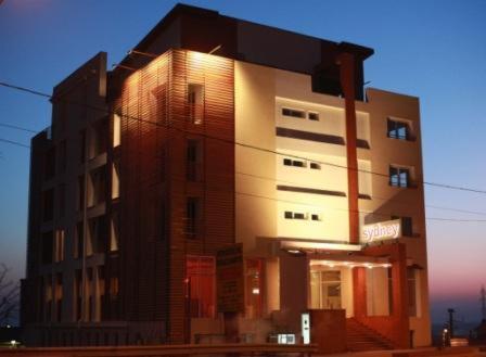 a tall building with the light shining on it at Hotel Sydney in Craiova
