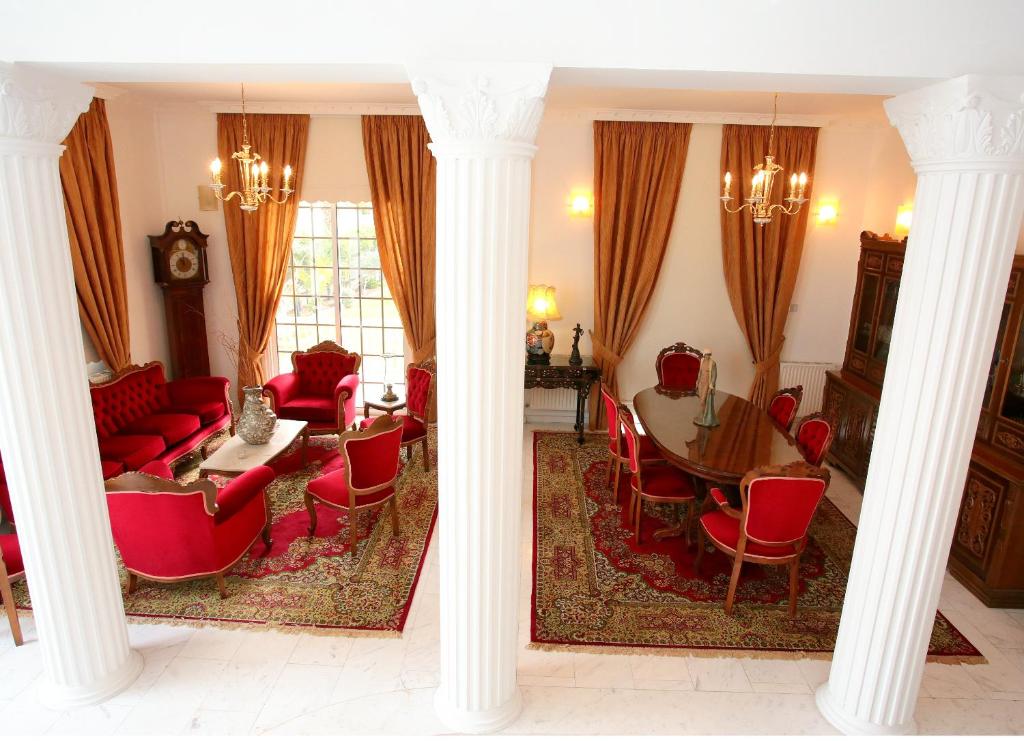 een woonkamer met zuilen en een tafel en stoelen bij The White House in Larnaka
