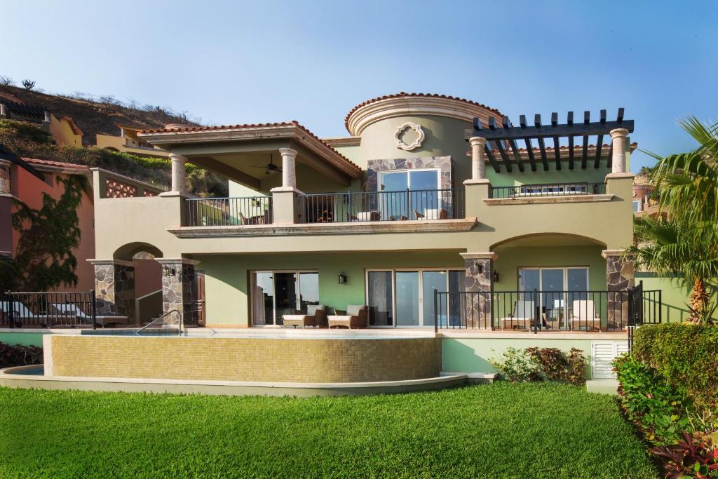 a large house with balconies and a yard at Montecristo Villas at Quivira Los Cabos -Vacation Rentals in Cabo San Lucas