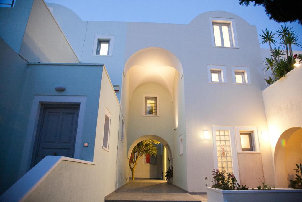 a house with white walls and a blue door at Atrium Villa in Fira