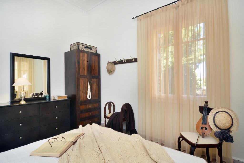 ハニア・タウンにあるHaralabos Central Apartmentのベッドルーム1室(ベッド1台、ドレッサー、ギター付)