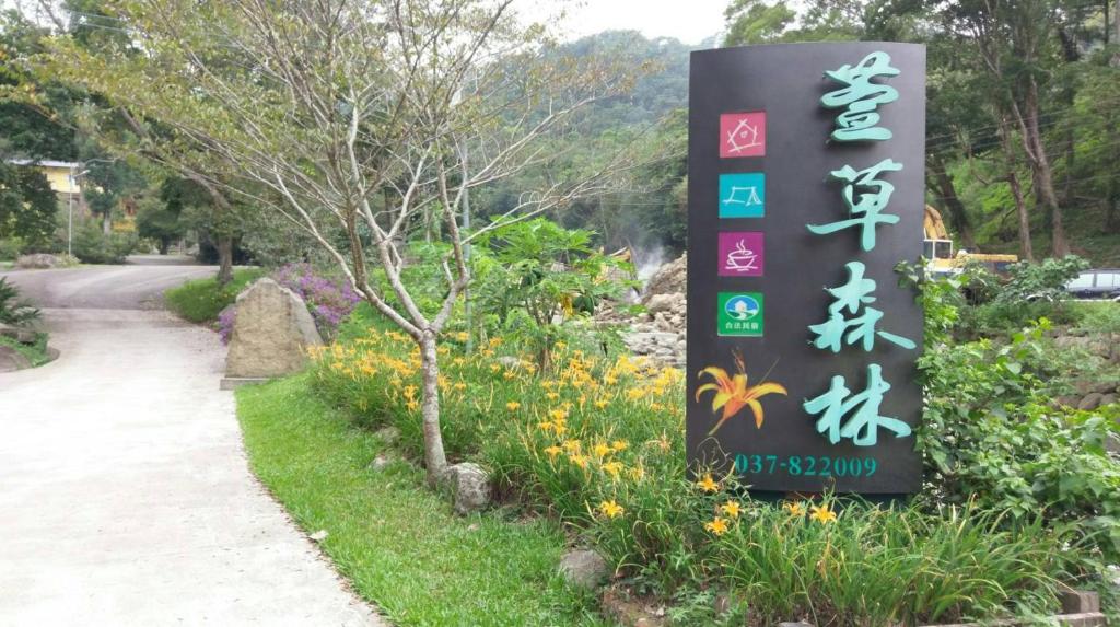 a sign for a park with flowers and a path at Hemerocallis Country House in Nanzhuang