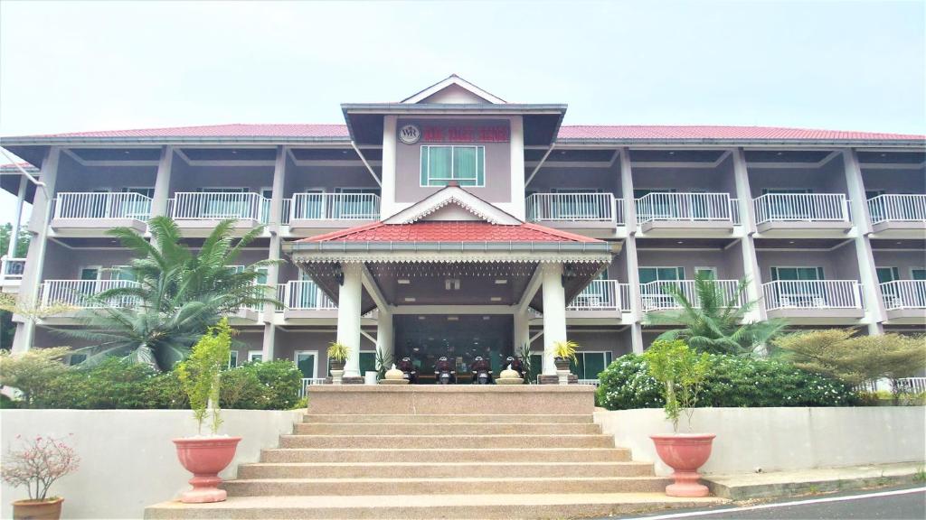 a large building with stairs in front of it at Wang Valley Resort in Pantai Cenang
